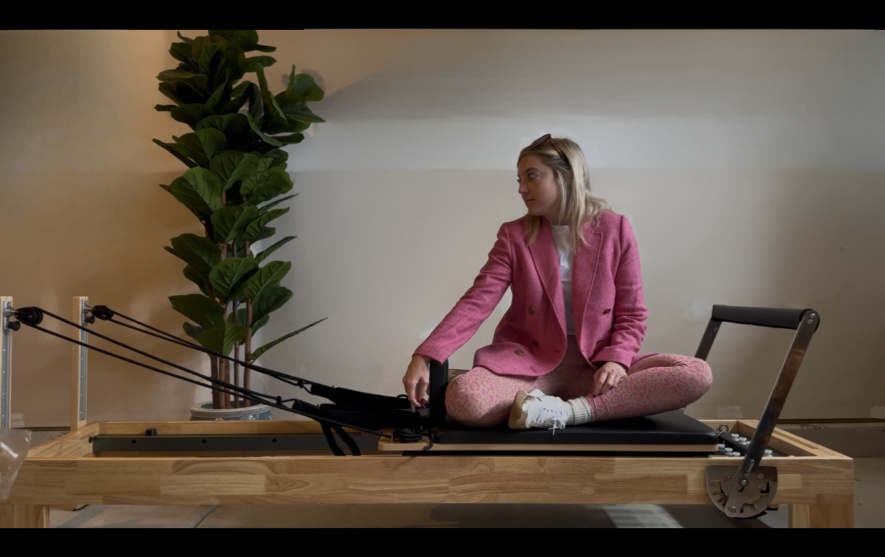 Woman practicing pilates and yoga in soft pink athleticwear